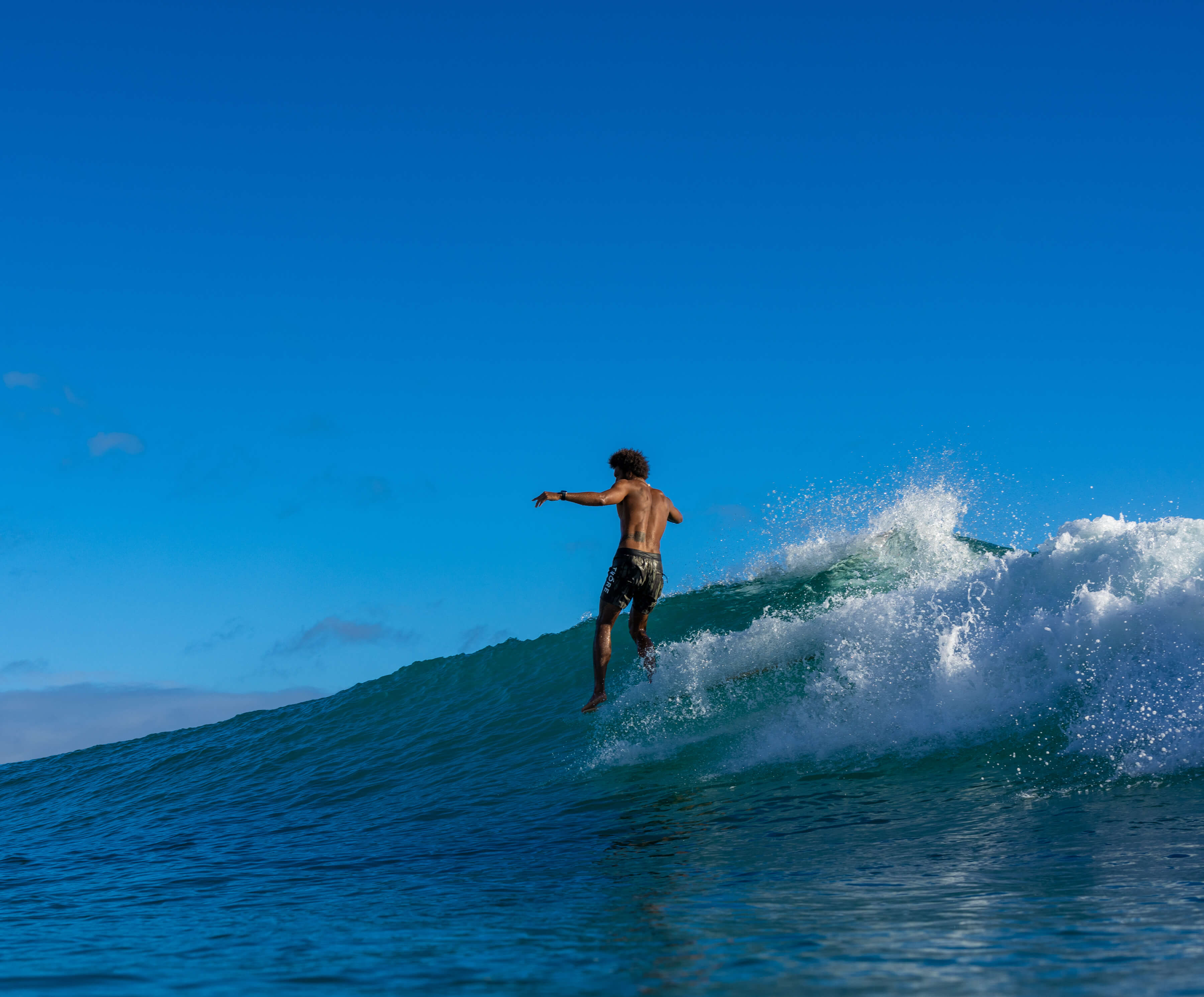 man riding wave with large splashes behind him