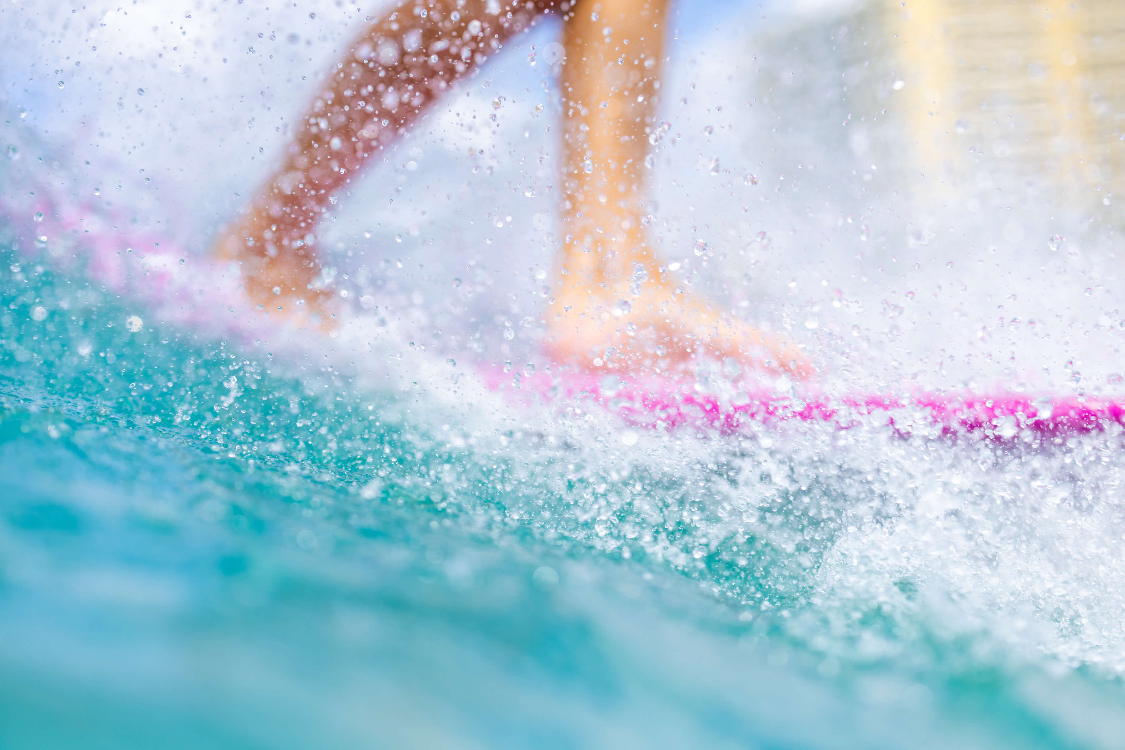 closeup of water droplets hitting a surfboard
